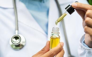 A doctor holding a bottle of CBD oil